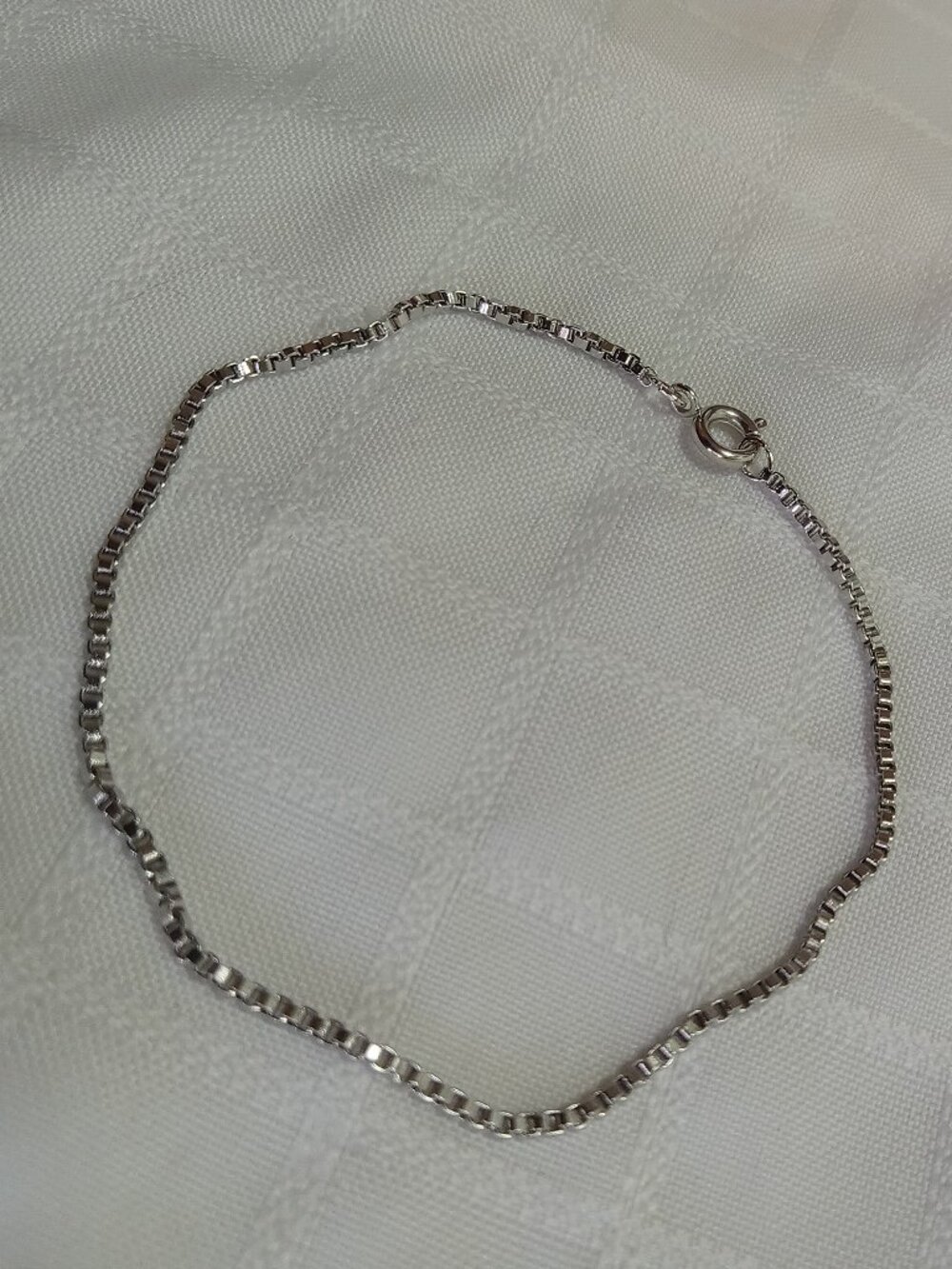 Tiny handmade bracelet with a squared chain in a silver color